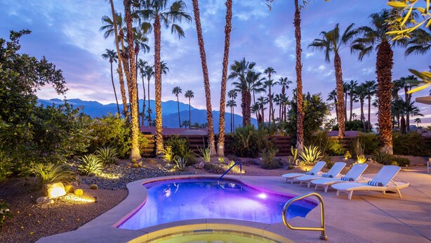 A pool area with lounge chairs and palm trees, surrounded by desert landscaping and mountains in the background. - Modern Loma Vista (Palm Springs)