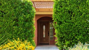 A traditional building with a wooden facade, a central arched doorway, and a small porch area. - Modern Loma Vista (Palm Springs)