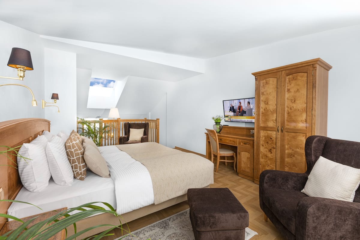 Une chambre à coucher comprenant un lit, un bureau, une chaise, une armoire et un canapé.