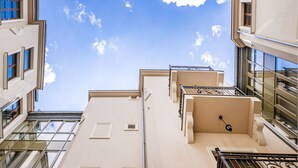 A high-rise building with multiple balconies and large windows, offering views of the sky and clouds. - Ventus Rosa Boutique Aparthotel (Kraków)