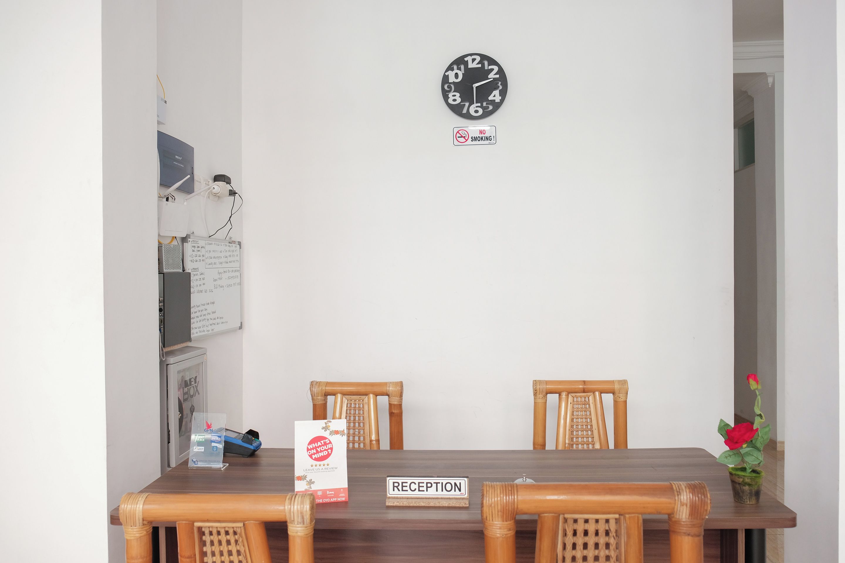Un área de recepción con un reloj, un letrero de 'No fumar', un mostrador de recepción y un cartel que dice '¿Qué te preocupa?'.