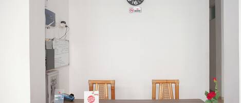 Un área de recepción con un reloj, un letrero de 'No fumar', un mostrador de recepción y un cartel que dice '¿Qué te preocupa?'.