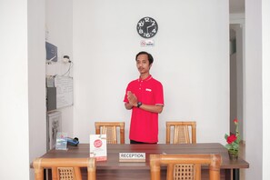 Ein Empfangsbereich mit einem Holzbüro, einer Uhr und einem Rauchverbotsschild.