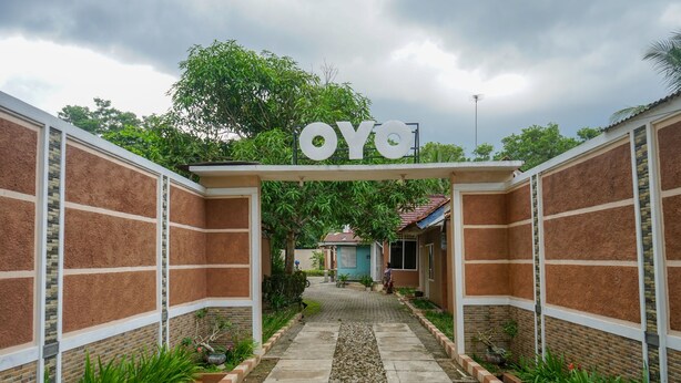 A pathway leading to a building with a sign reading "OYO". - Hotel O Jatimas (Merawang)