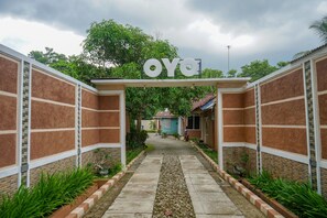 A pathway leading to a building with a sign reading "OYO". - Hotel O Jatimas (Merawang)