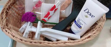 A wicker basket containing Dove skincare products, a hairbrush, and a purple flower.