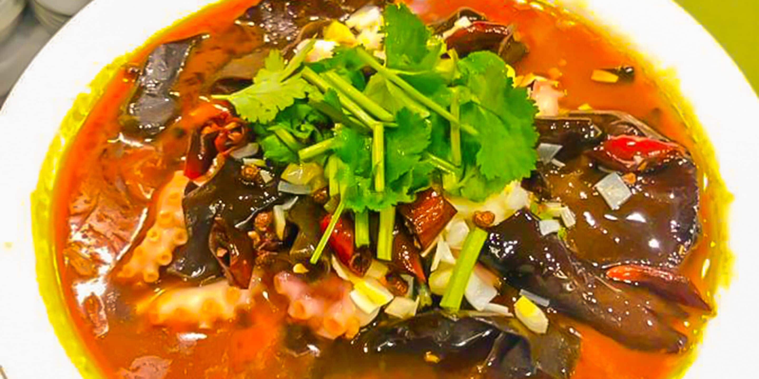 A dish with various ingredients and a garnish of green herbs.