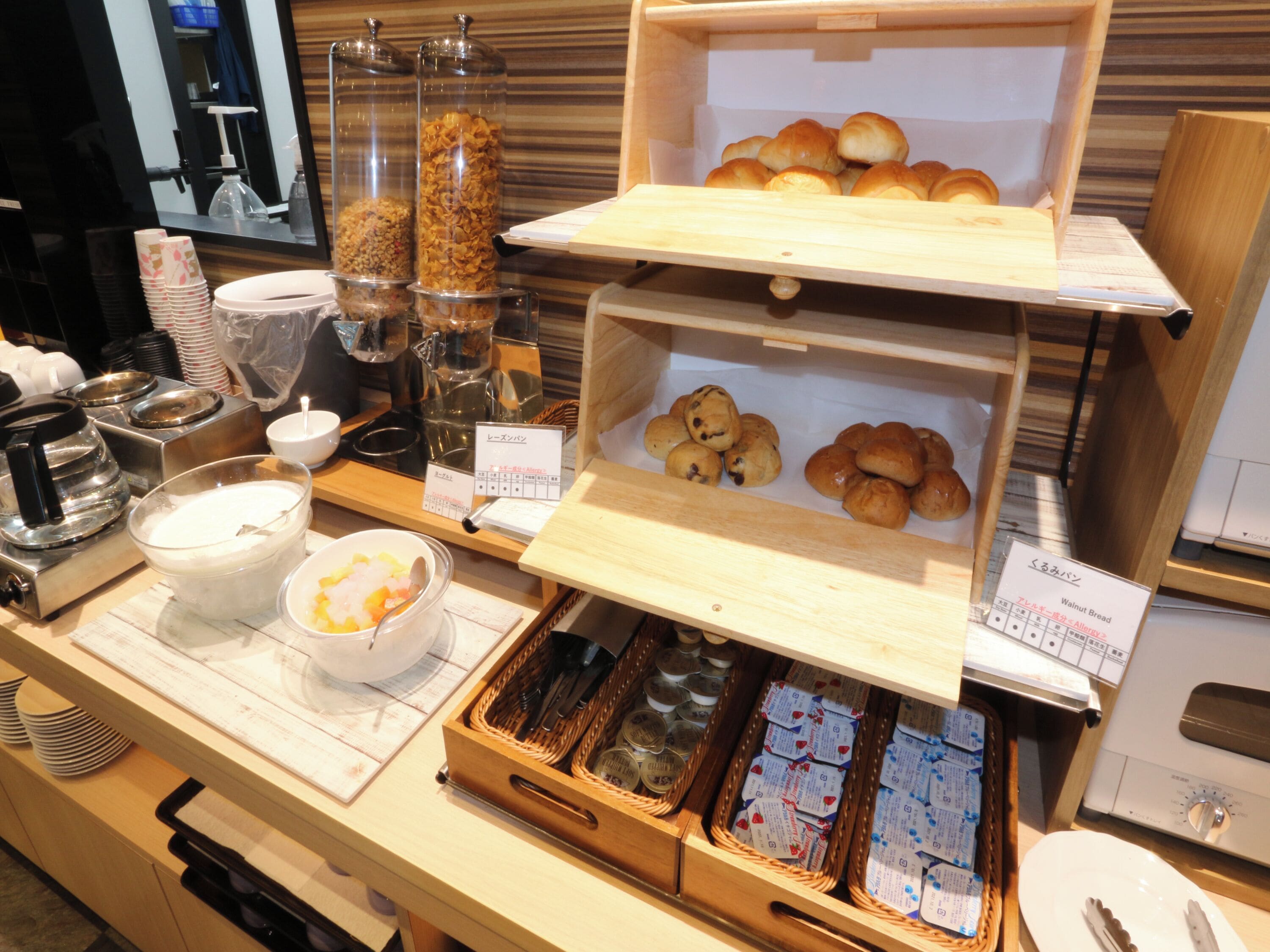 Un banco buffet con diversi alimenti, tra cui cereali, biscotti e prodotti confezionati.