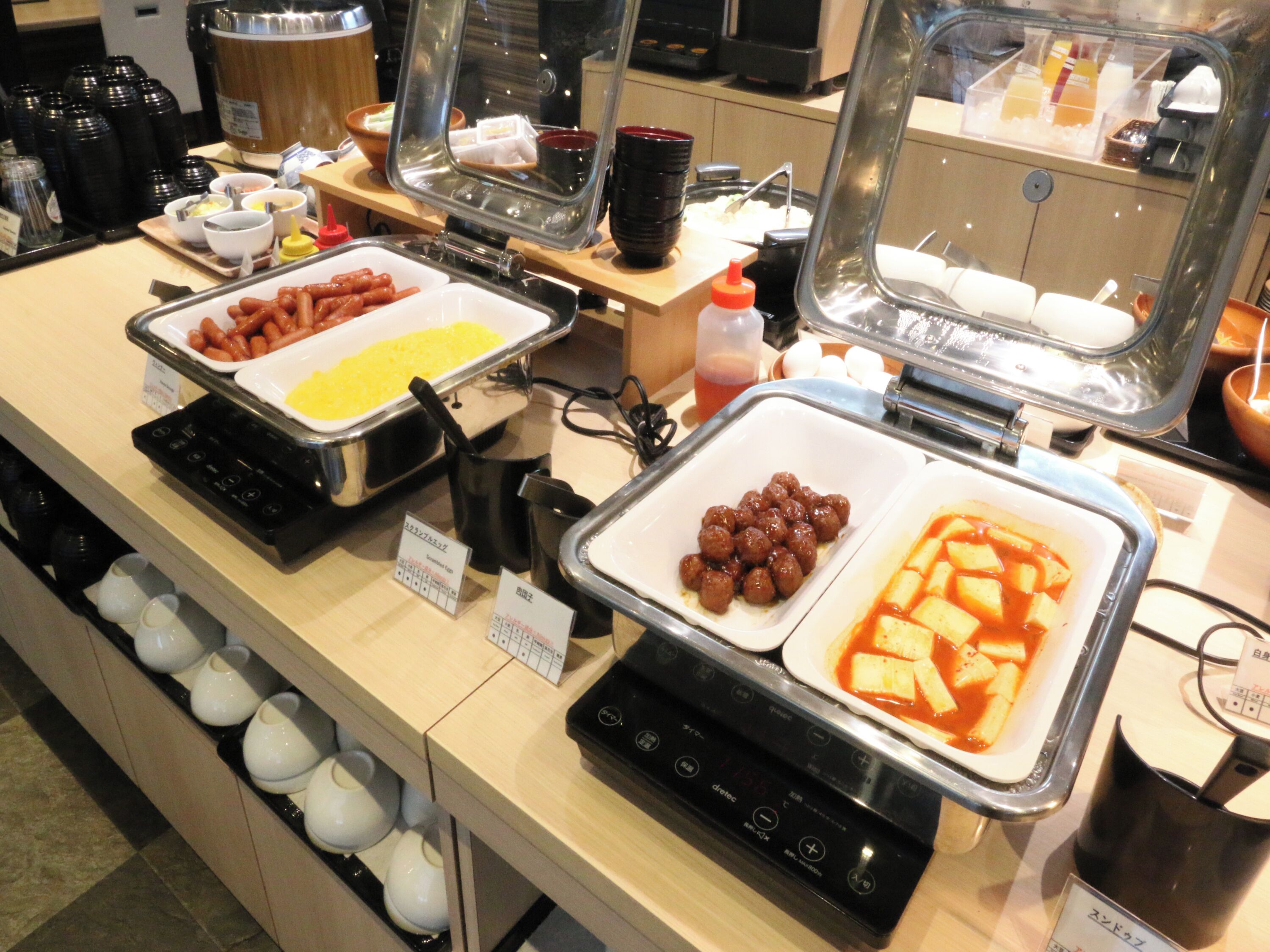 A buffet with various food items and a coffee machine.