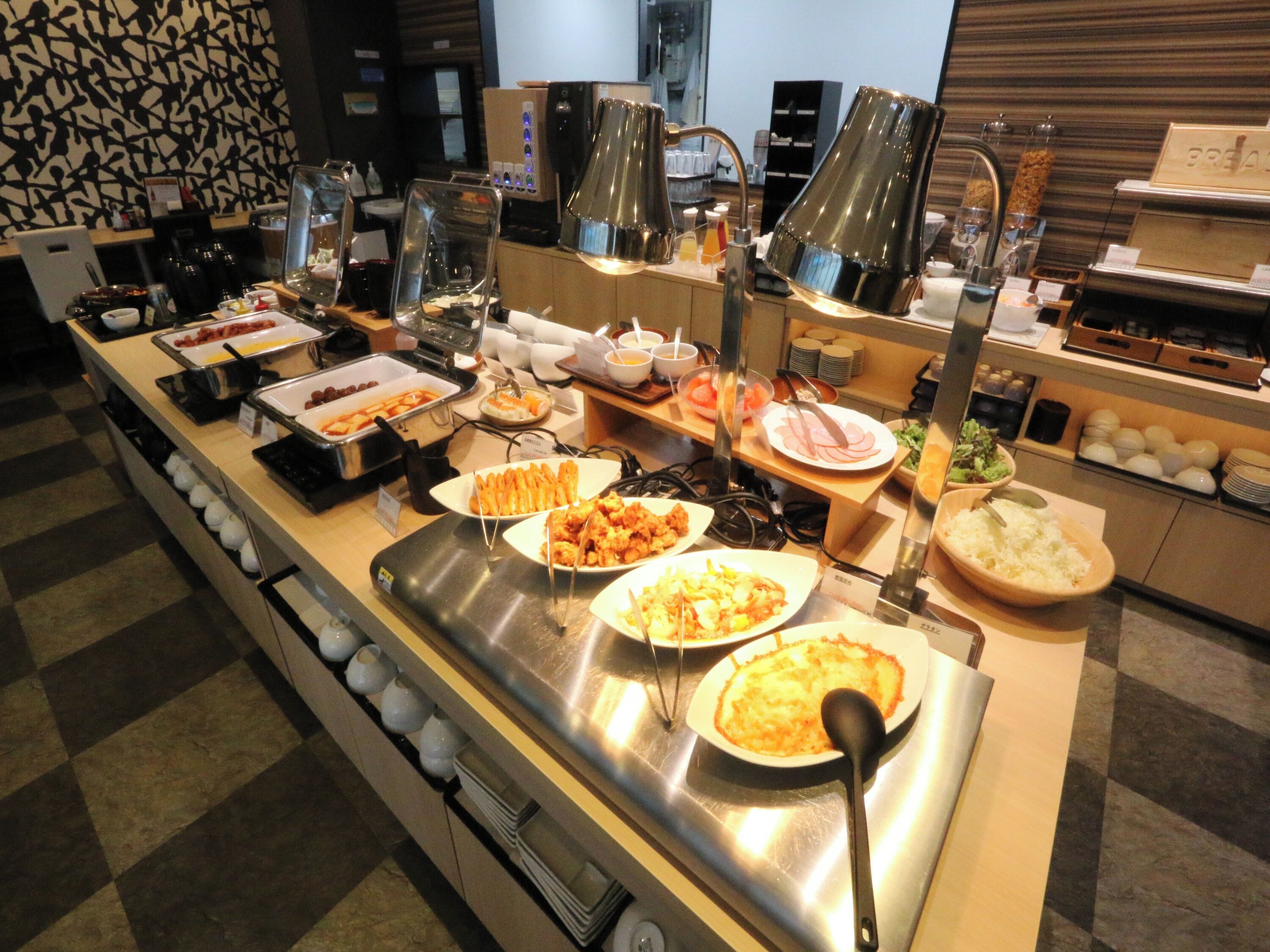 A buffet with various food items and a coffee station.