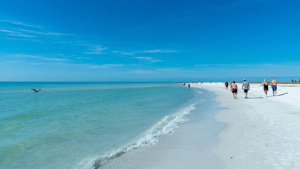 Een strand met helder turquoise water en een zandstrand.