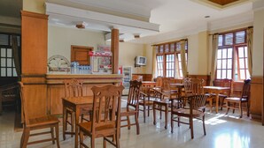 Eine Hotelhalle mit Holzmöbeln, einer Rezeption und einem Fernseher.