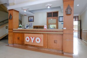 Una recepción con un cartel que dice "OYO" en el vestíbulo de un hotel.