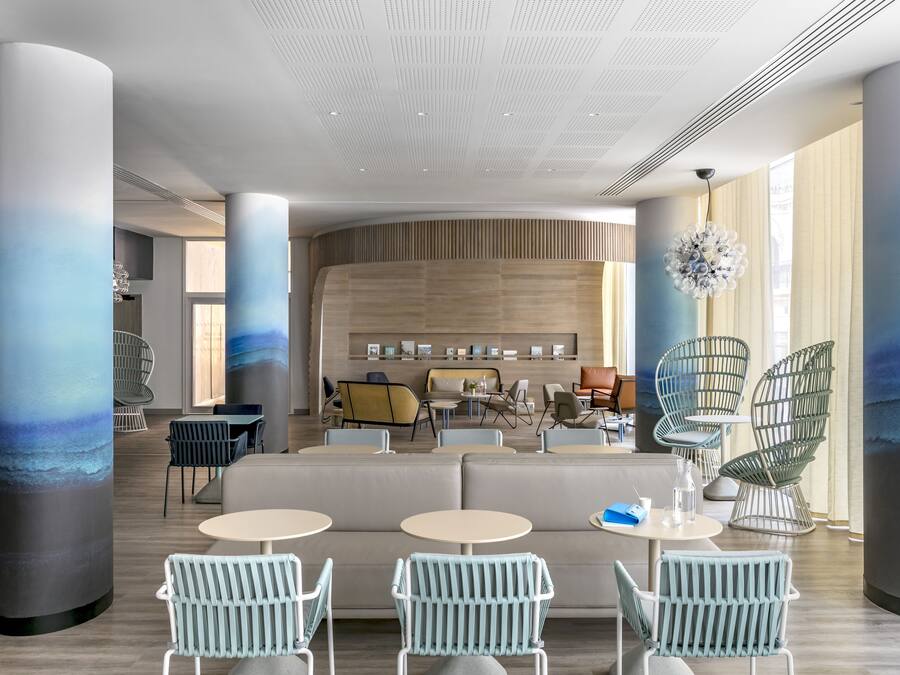 A modern interior with a seating area, tables, and a large wall with a wooden panel design.