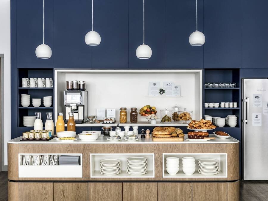 A buffet setup with various food items, utensils, and storage shelves.