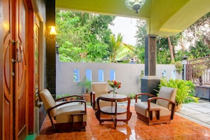 A patio with two chairs, a table, and a potted plant. - Hotel O Opak Village Bed & Breakfast (Jetis)