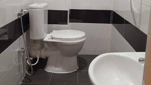 A small bathroom with a toilet, bidet, and sink. - Comfortable Stay (George Town)
