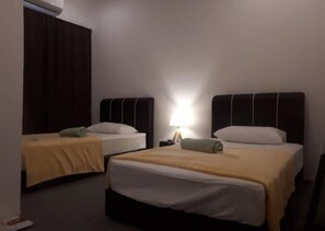 A hotel room with two single beds, a nightstand with a lamp, and a dark curtain.