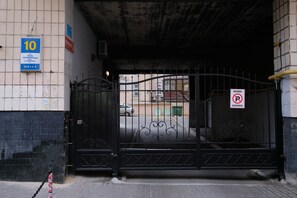 Una entrada con reja, un letrero de ‘prohibido estacionar’, un cartel azul con el número 10 y una reja metálica con detalles decorativos.