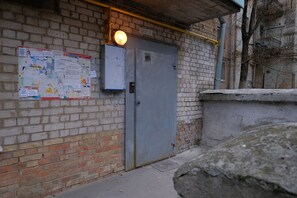 Un muro de ladrillo con una puerta y un tablón de anuncios lleno de papeles.