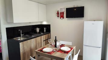 Junior Mobile Home | Private kitchen | Full-size fridge, stovetop, cookware/dishes/utensils, dining tables