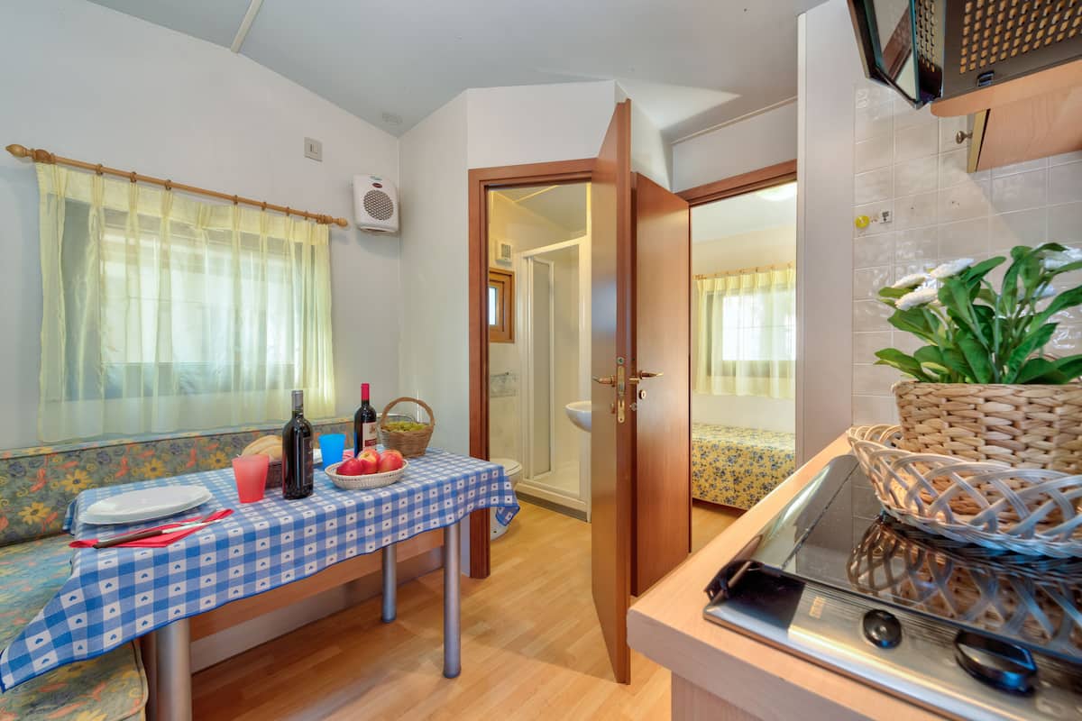 A compact kitchen with a dining area, a microwave, and a sink.