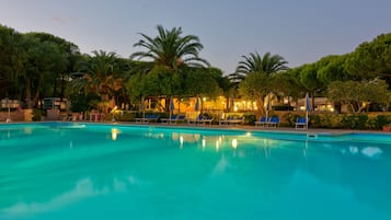 Una piscina al aire libre de temporada, sombrillas