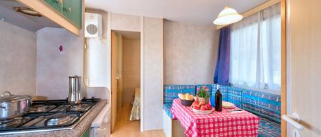 Cocina compacta con estufa a gas, un lavamanos y ventana con vistas.