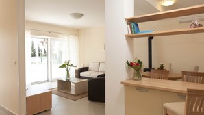 A modern living room with a sofa, coffee table, and dining area. There is a sliding glass door leading to a balcony. - Vila Morska Sirena (Zupa dubrovacka)