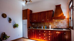 Een keuken met houten kastjes, een inbouwfornuis en een raam.