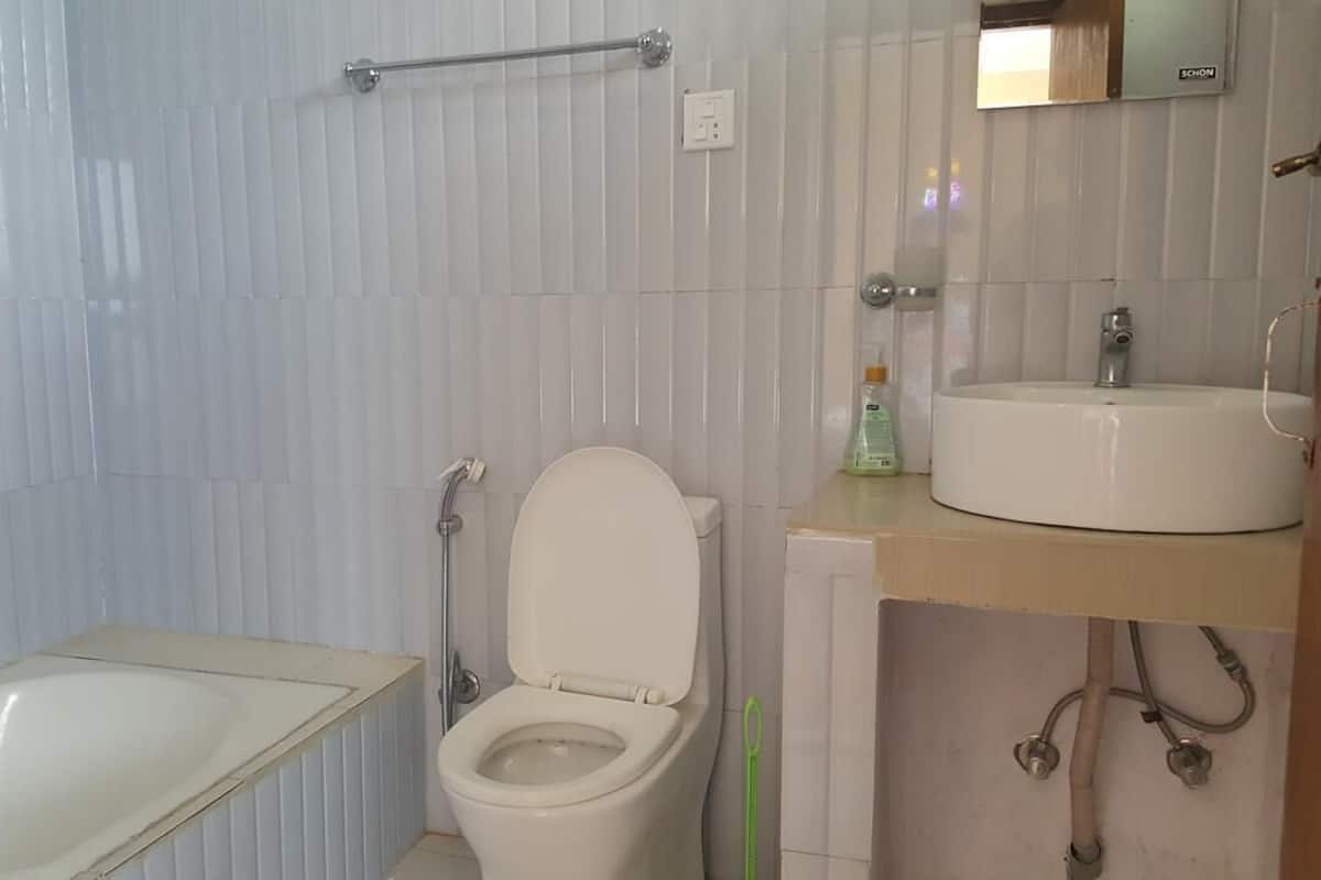 A bathroom with a toilet, a sink, and a shower area.