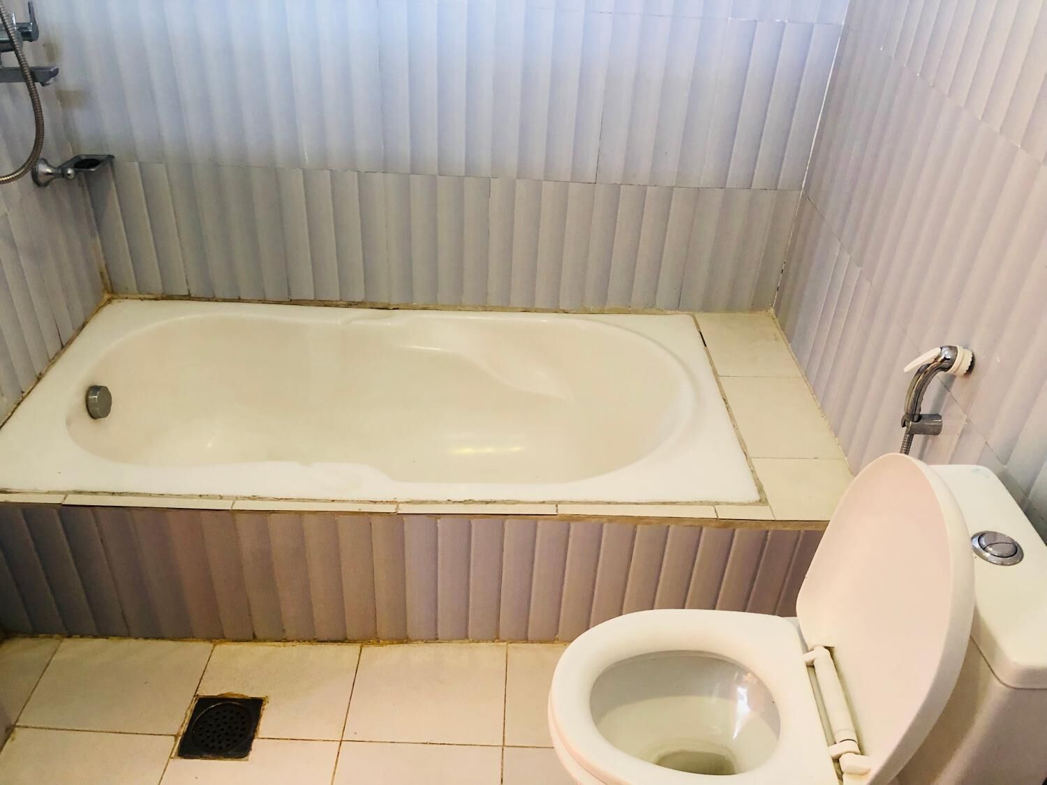 A bathroom with a bathtub, toilet, and a shower.