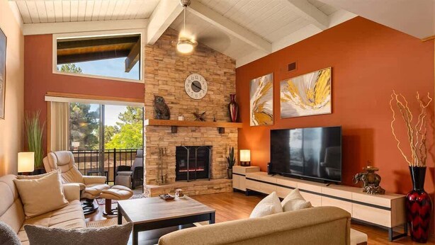 Una sala de estar con chimenea, televisor y sofá.