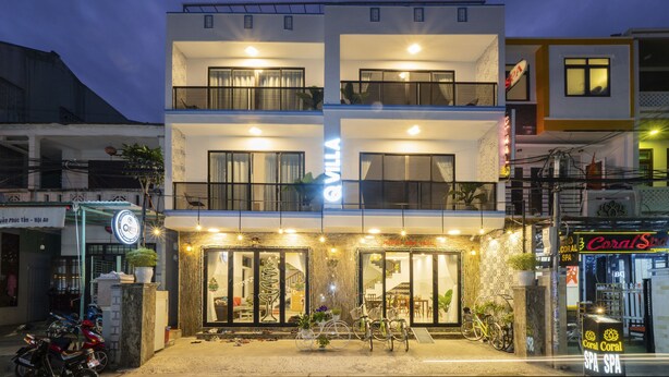 A multi-story hotel with a ground-level entrance, balconies, and a visible spa sign. - Q Villa Hoi An (Da Nang)