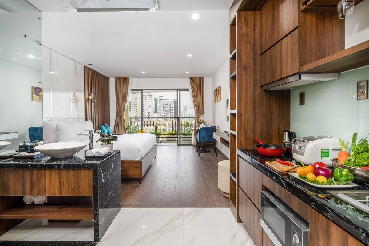 A modern kitchen with a black countertop, a white sink, and wooden cabinets.