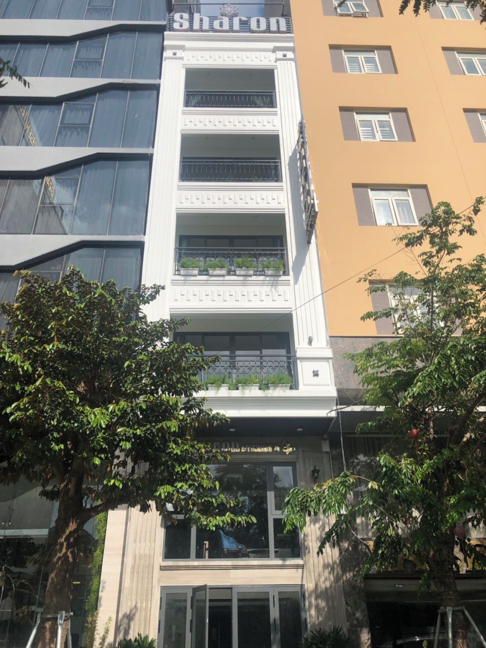 A multi-story building with a prominent 'Sharon' sign on the facade.