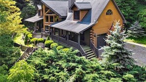A log cabin with a porch, multiple windows, and a chimney. - Views, privacy, Kids Playhouse, Easy Access, Fast WiFi! Gated community (Waynesville)