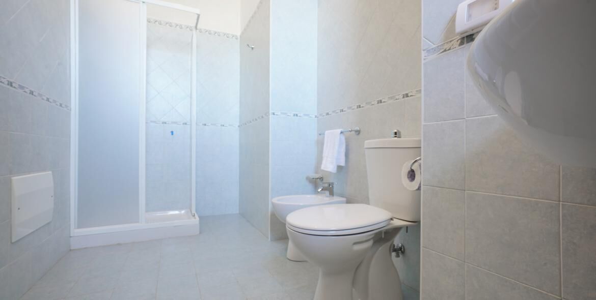 A bathroom with a shower, toilet, and sink.