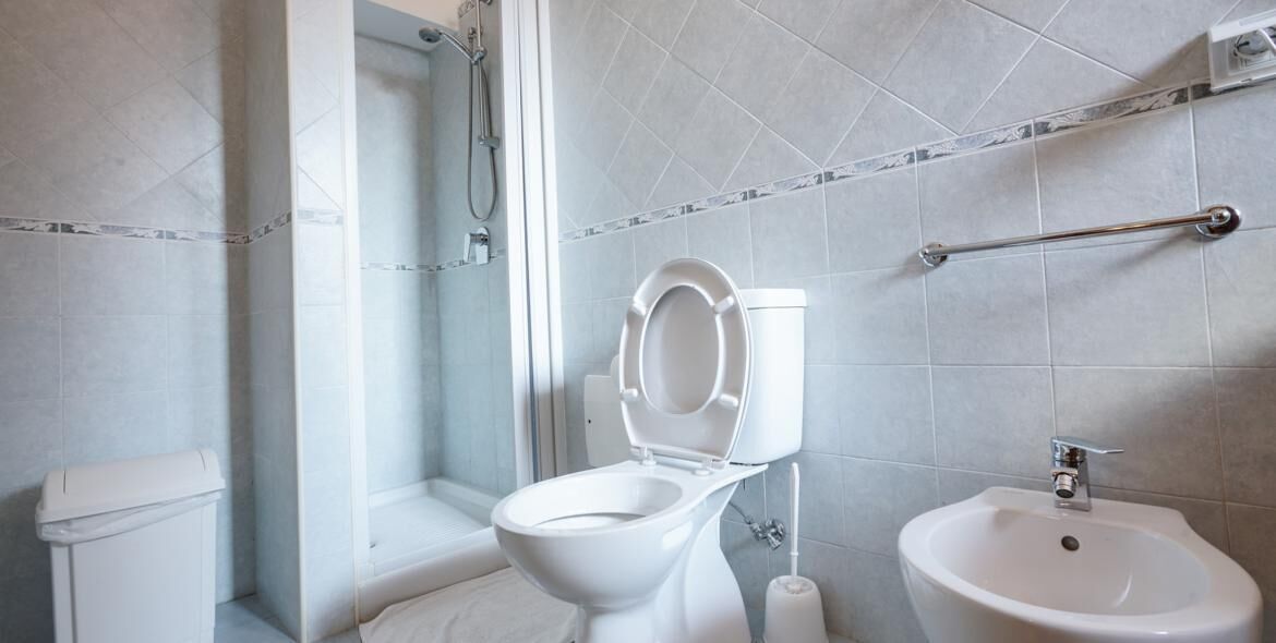A modern bathroom with a toilet, bidet, and sink.