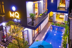 A multi-story hotel with a pool, balconies, and indoor plants. - MQ Villa (Da Nang)