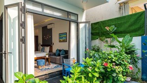 A modern interior with a bed, sofa, and a dining area. - MQ Villa (Da Nang)