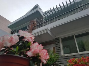 A two-story house with a balcony, a brick chimney, and a window. - Byulbam - Hostel (Gwangju)