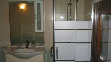 Un baño con lavamanos, espejo y ducha.