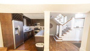 A modern kitchen with stainless steel appliances, wooden cabinets, and a central island. - Ski Home with Hot Tub and King Beds (Sandy)
