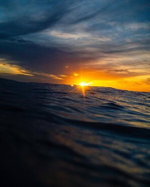 Un atardecer sobre el océano con olas.