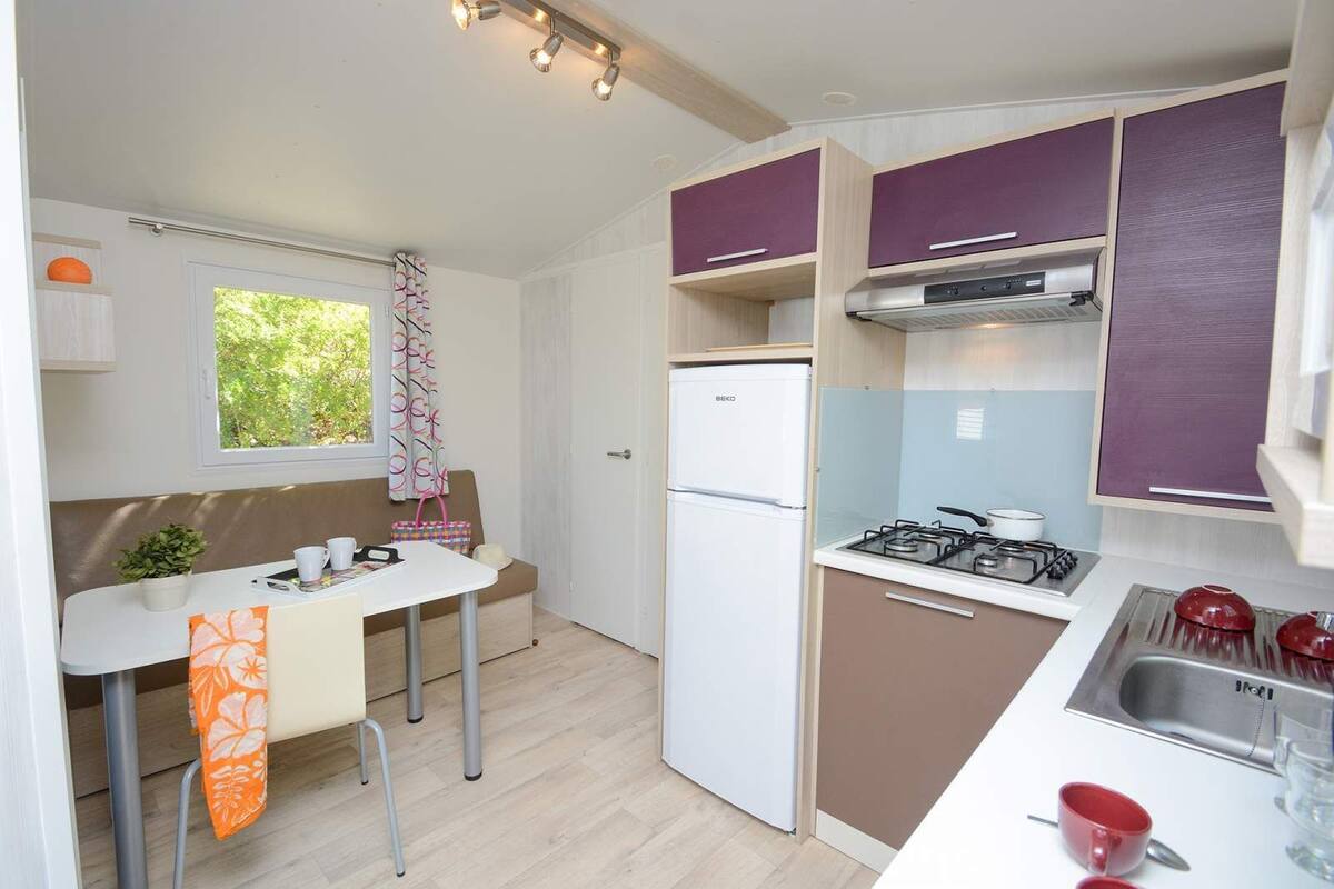A compact kitchenette with a refrigerator, stove, and sink.
