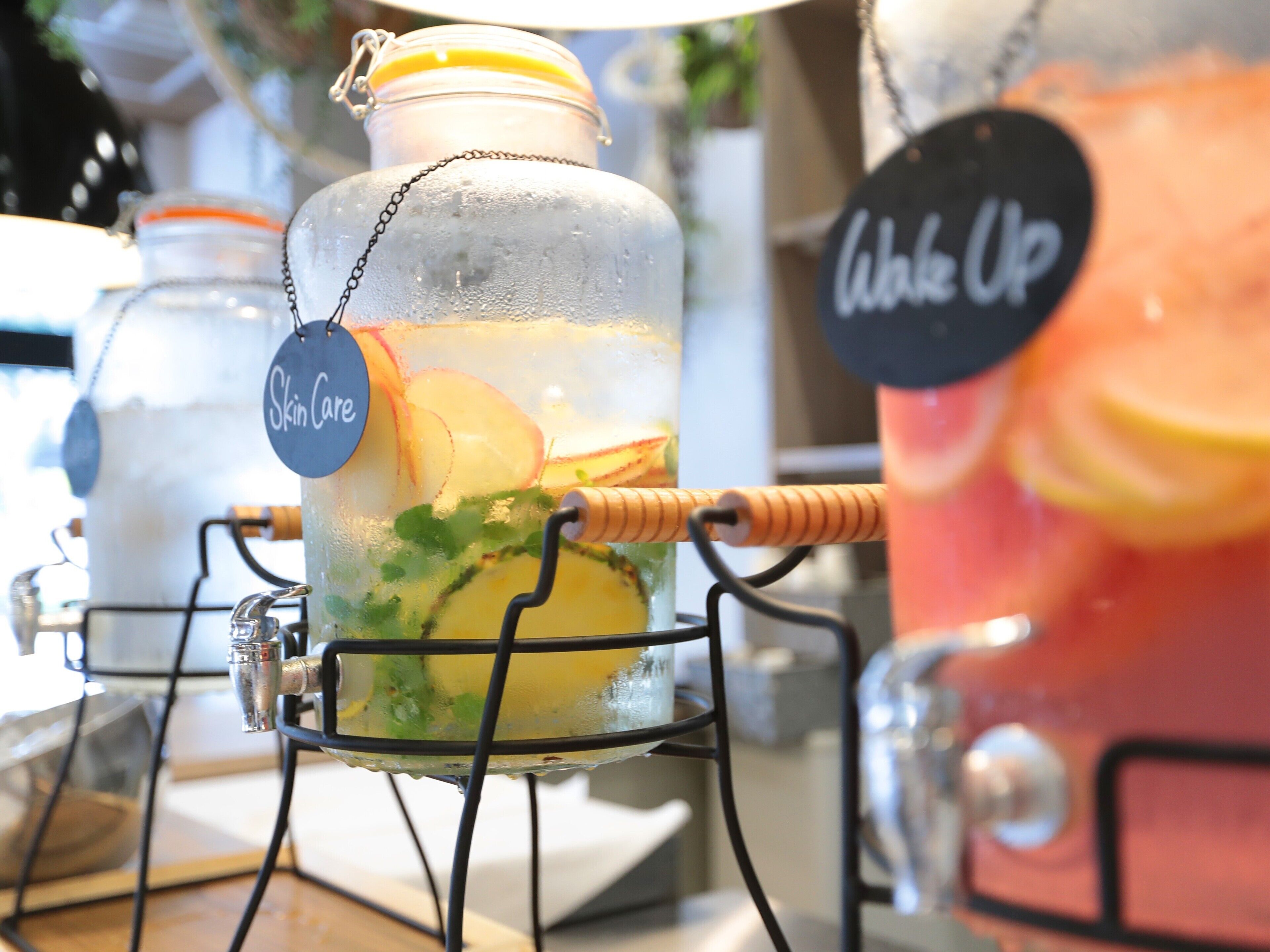 Un dispensador de bebidas con una etiqueta que dice 'Skin Care' y un letrero que dice 'Wake Up'.