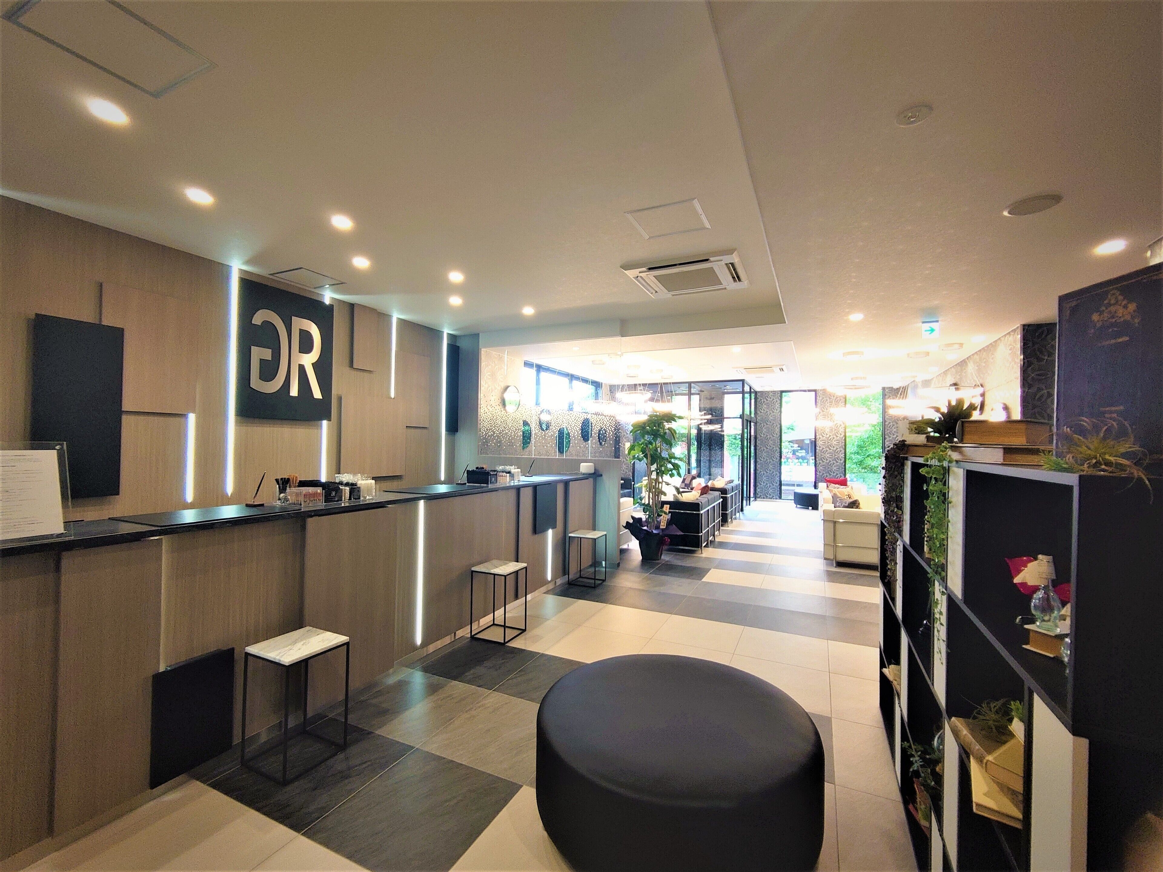 A modern reception area with a counter, seating, and a view into the lobby.