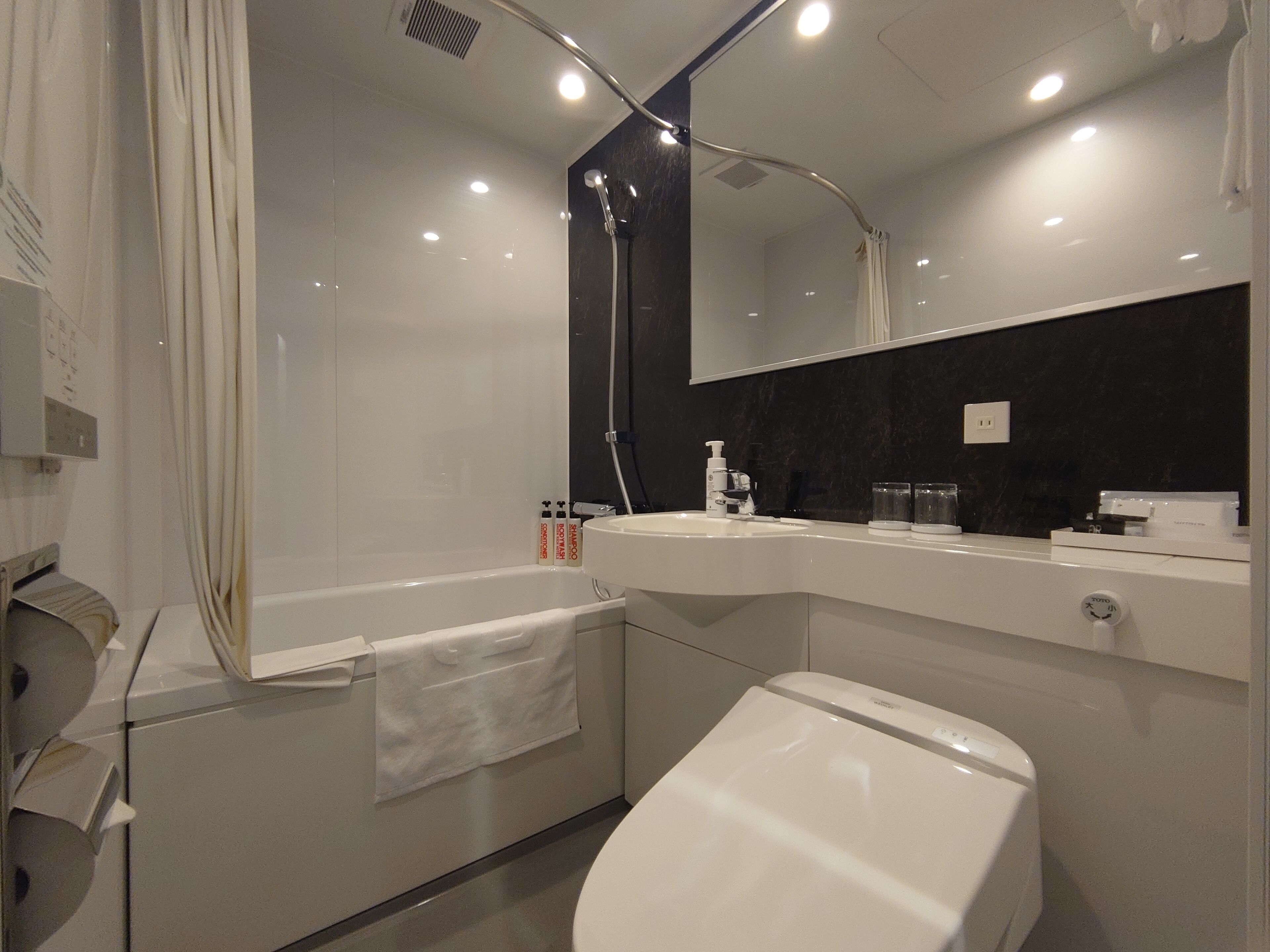 Un baño moderno con bañera, inodoro, lavabo y espejo.