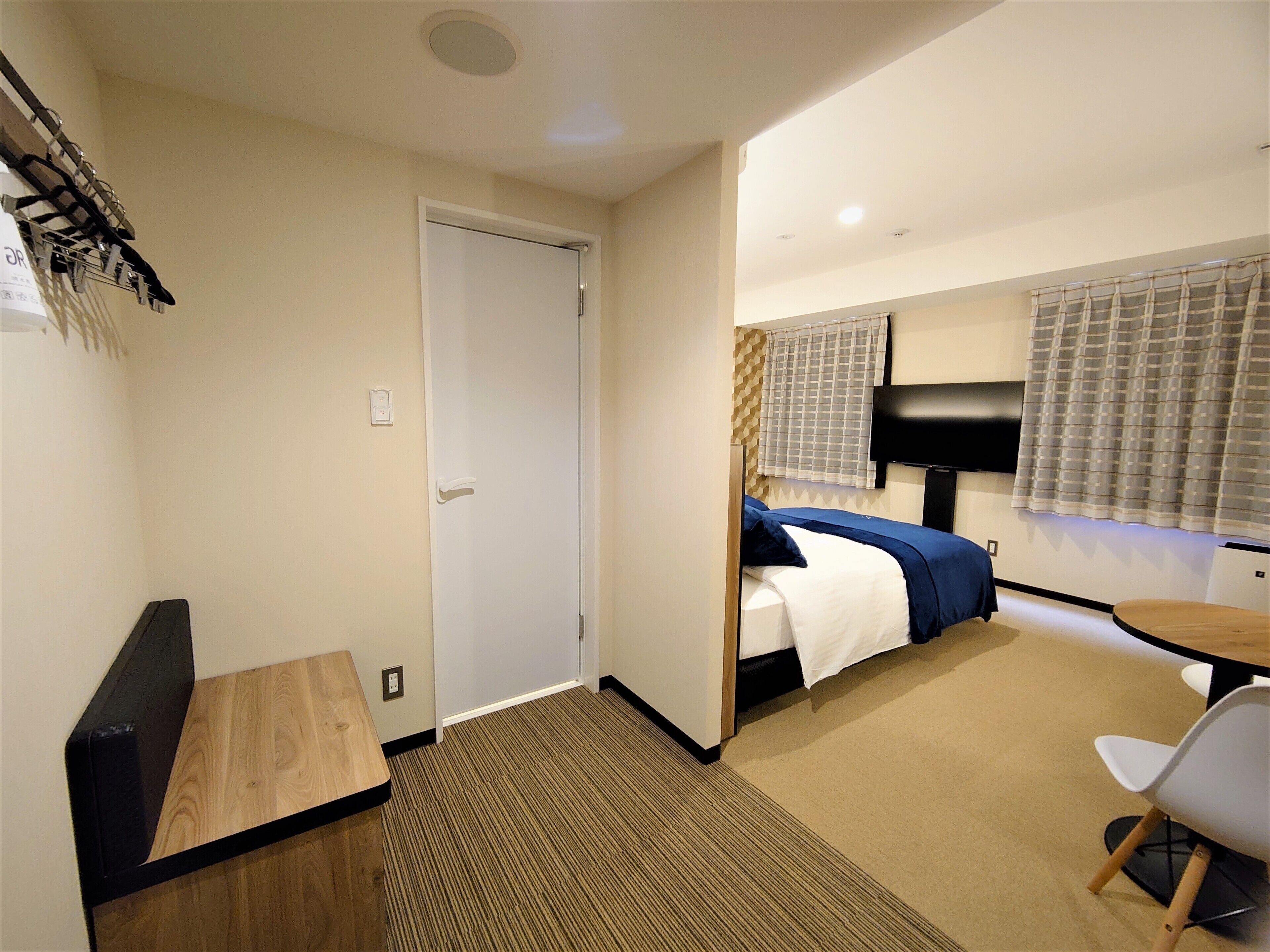 Una habitación de hotel con una cama, un escritorio, una silla y un televisor.